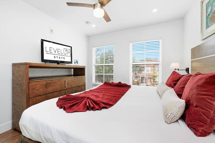 Просторна спалня с естествена светлина и телевизор