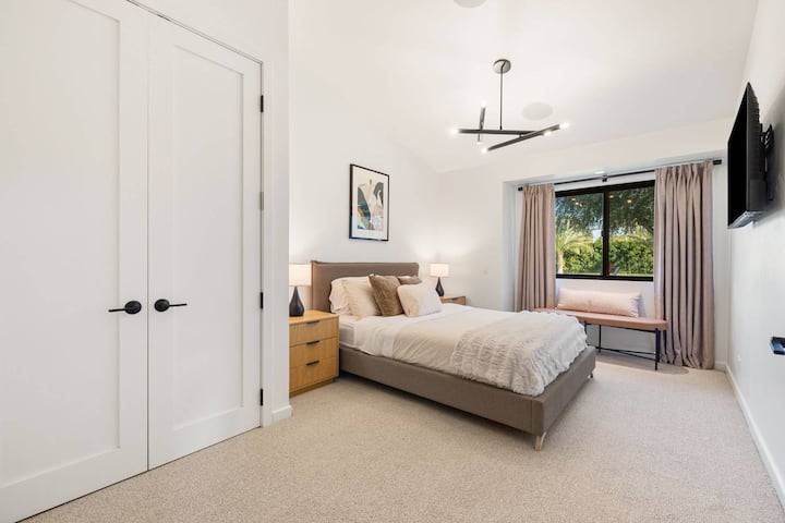 Primer dormitorio: dormitorio para huéspedes con cama queen y televisor