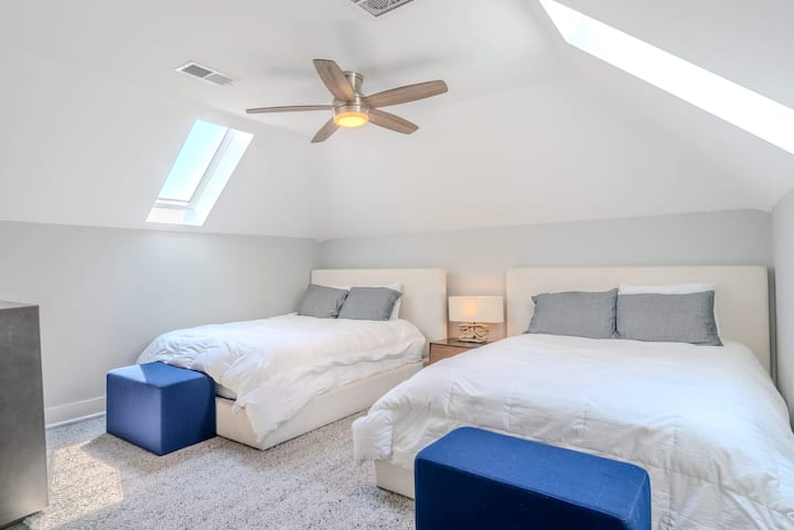 Slaapkamer 4 met twee queensize bedden en een wieg, perfect voor gezinnen.