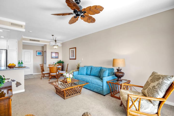 Ruime woonkamer met een queensize slaapbank, grote ramen en directe toegang tot de lanai.