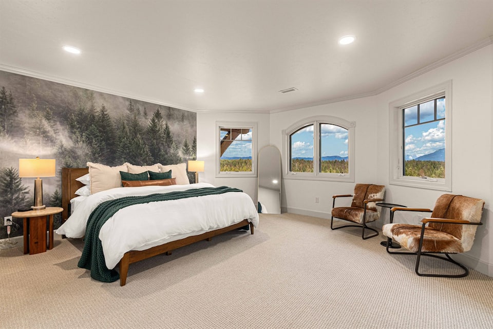 King bedroom with morning light through tall windows