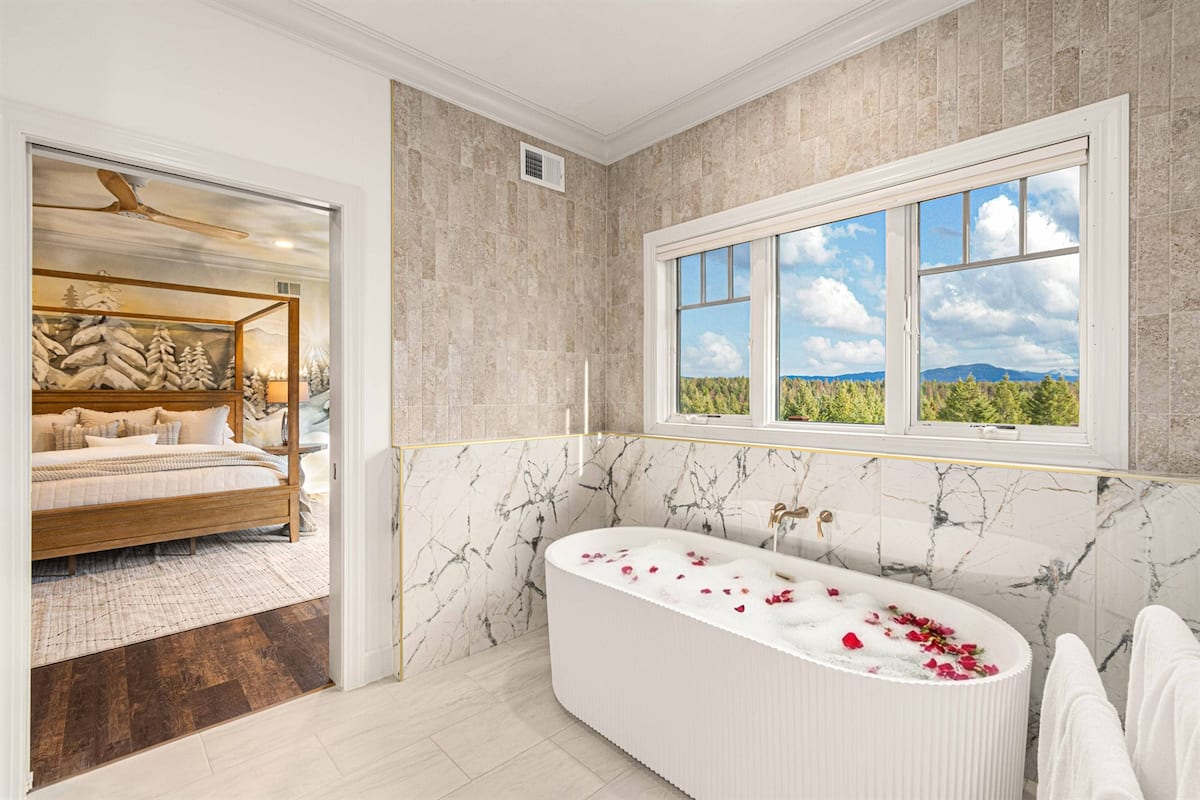 Spa-style en-suite bath with deep soaking tub and mountain glass in the master suite