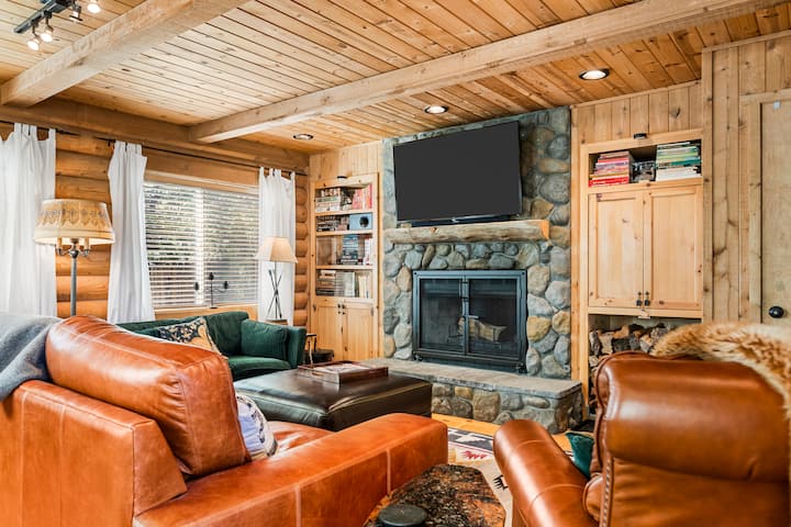 Sala de estar con televisor inteligente, cómodos asientos y chimenea, ideal para relajarse con comodidad y estilo.