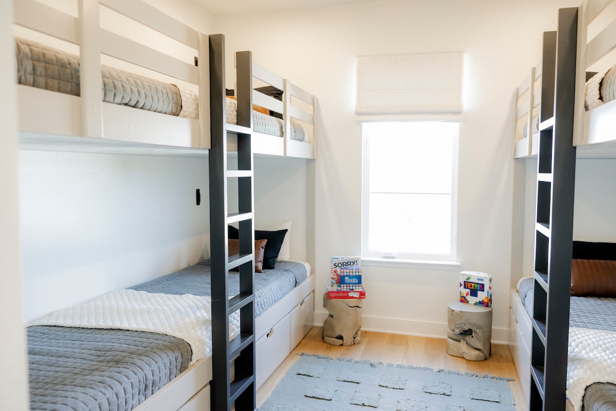 Habitación luminosa con 4 literas y espacio de almacenamiento, perfecta para niños y grupos.