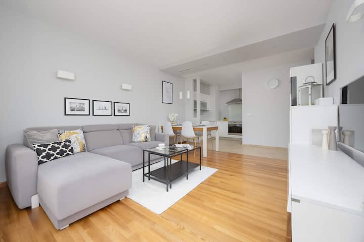 Una luminosa sala de estar con una gran ventana y un cómodo sofá invita a la relajación, creando un espacio perfecto para pasar tiempo juntos.