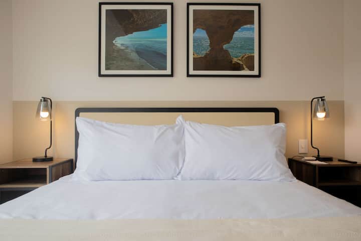 Dormitorio con obras de arte enmarcadas de temática azul.