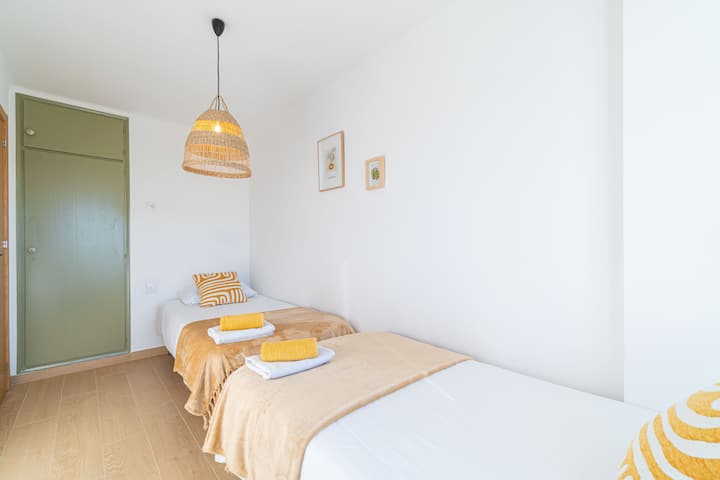 Segundo dormitorio luminoso con dos camas individuales y bonitas vistas, ideal para niños, amigos o familias.