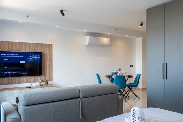 Luminoso salone open space con comodo divano, zona pranzo e una moderna atmosfera rilassante