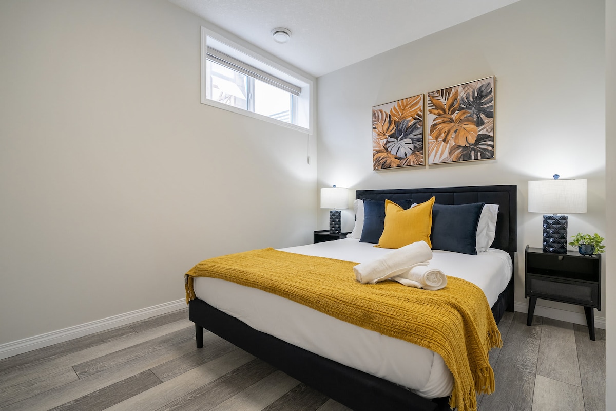 舒适的标准双人床卧室，配有柔和的灯光和毛绒床上用品，让您安然入睡