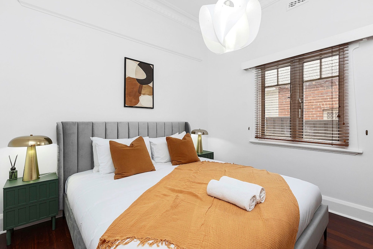 ملاذك الأنيق في انتظارك! استمتع بالسرير المريح والديكور المدروس والإضاءة المحيطة في غرفة النوم الهادئة هذه.