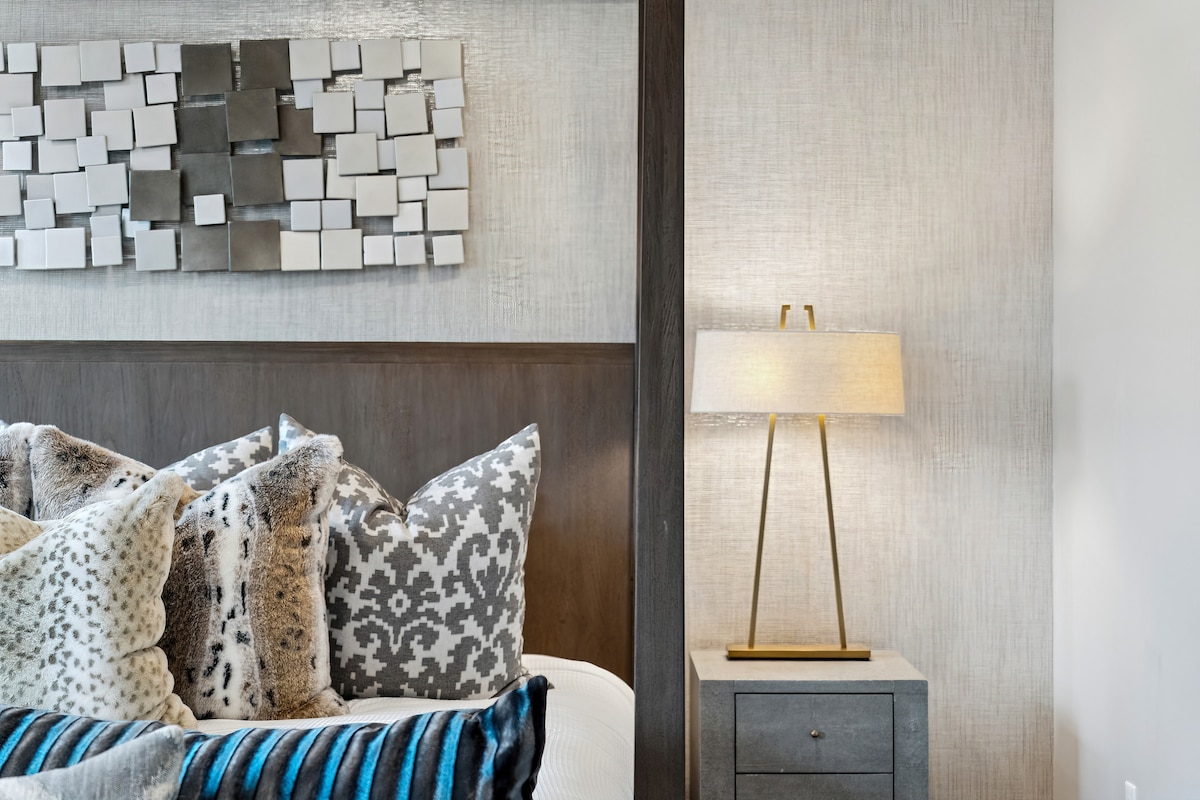 Крупен план на детали во спална соба со перници со текстура и амбиентално осветлување