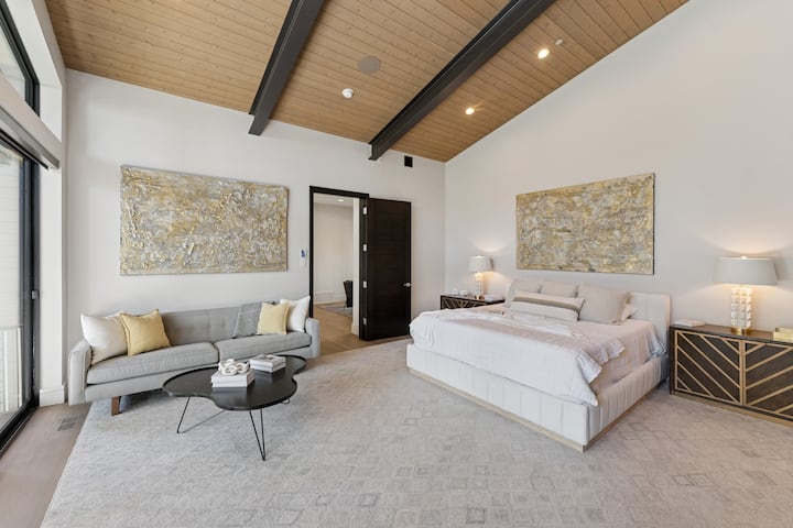 Elegant bedroom with vaulted ceiling, soft neutral tones, and contemporary design