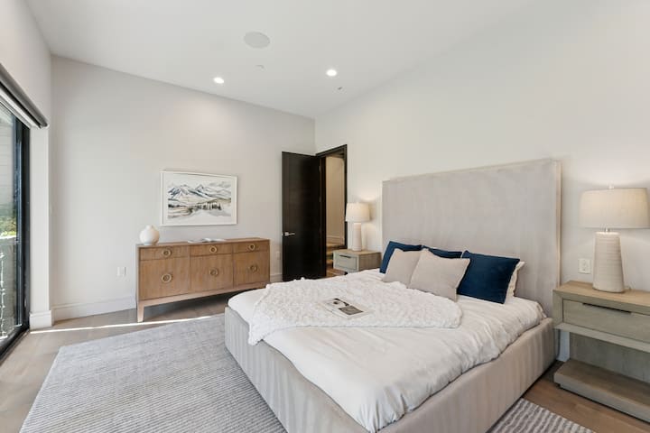 Bright bedroom with upholstered bed, minimalist design, and natural light