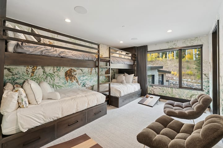 Luxury bunk suite with cozy seating area, large windows, and custom built-ins