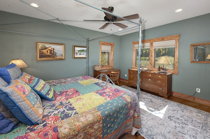 غرفة نوم في الطابق السفلي مع سرير كينج وحمام داخلي.