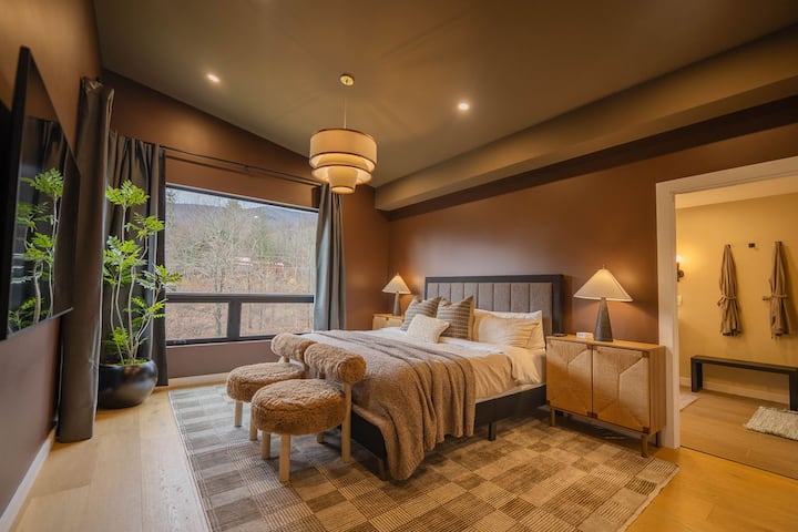 Primary suite with king-size bed and stunning Hunter Mountain views, peaceful retreat for deep rest.