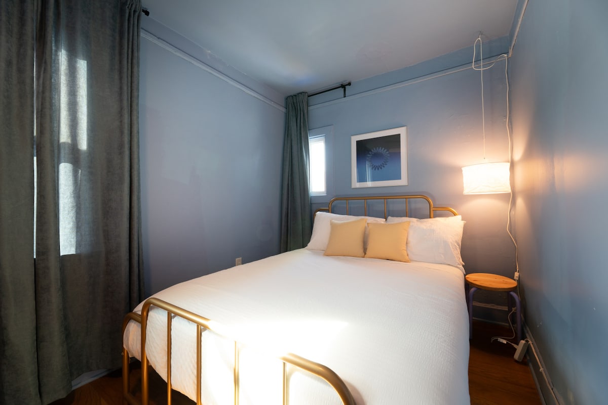 Dormitorio tranquilo con tonos azules suaves y una cama acogedora.