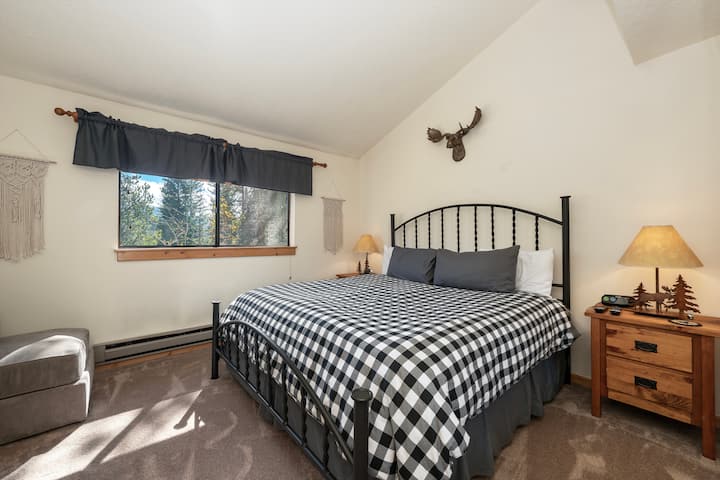 Acogedora habitación de montaña con vistas al bosque donde te despertarás con la luz del sol y un tranquilo paisaje boscoso a través de tu ventana.