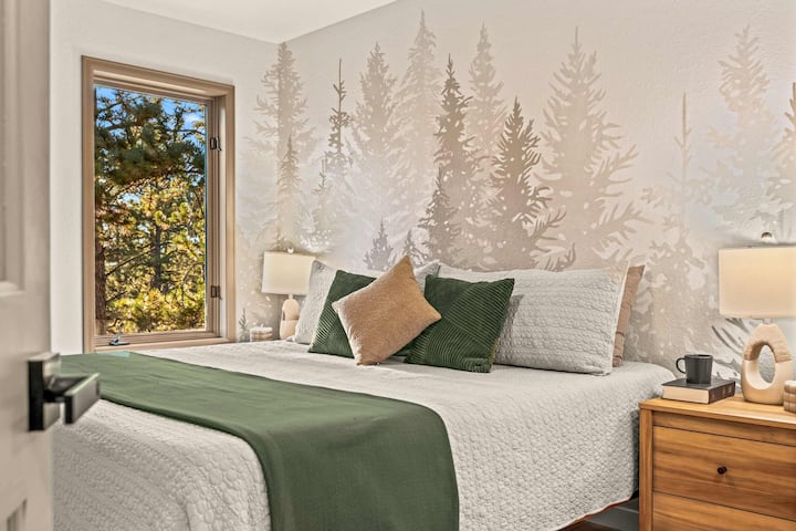 Forest-View King 2nd Bedroom – Hand-painted pine mural and plush bedding for a night of deep rest.