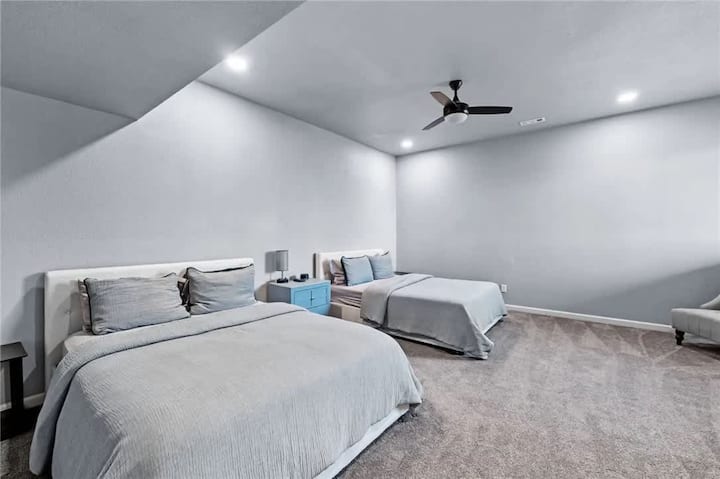 Priestranná izba pre hostí s dvoma mäkkými posteľami, moderným stropným ventilátorom a mäkkou posteľnou bielizňou – ideálna pre rodiny alebo skupiny.