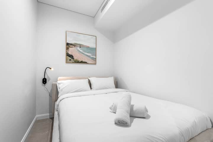 ห้องทำงานที่แปลงโฉมใหม่แบบมินิมอล มีเตียงคู่ Derucci งานศิลปะริมชายฝั่ง และโคมไฟอ่านหนังสือติดผนังสีอบอุ่นเพื่อการนอนหลับพักผ่อนอย่างเต็มอิ่ม