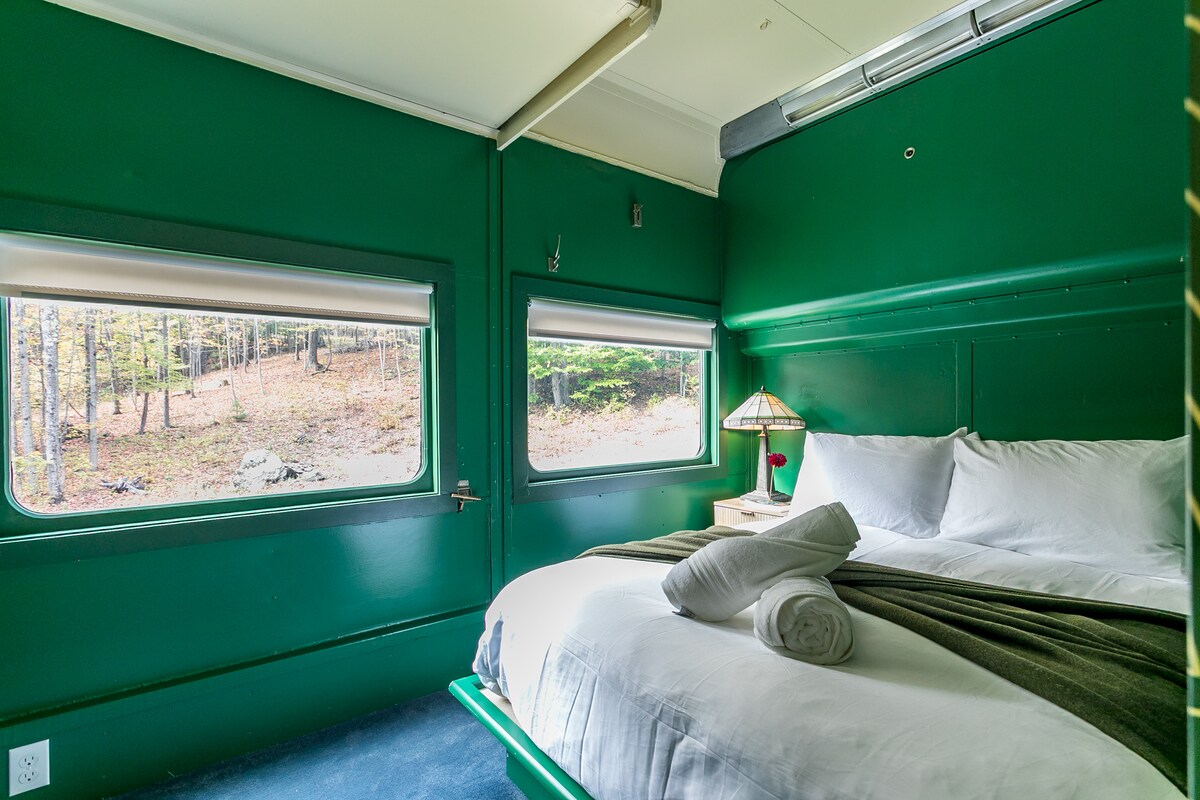 Ადირონდაკის აპარტამენტი აღჭურვილია კარადით, საწოლისპირა მაგიდით, სამოსითა და ჩუსტებით.