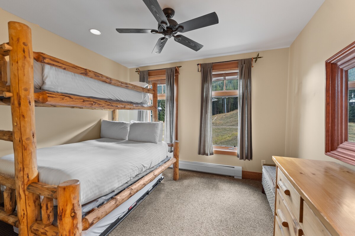 De slaapkamer voor gasten heeft een stapelbed met een queensize bed en een eigen badkamer. 