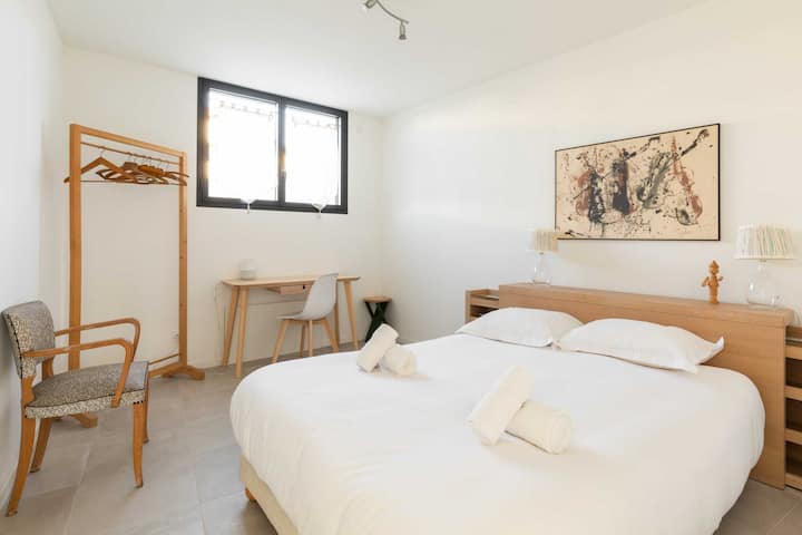 Una camera con letto matrimoniale, ripostiglio e scrivania.