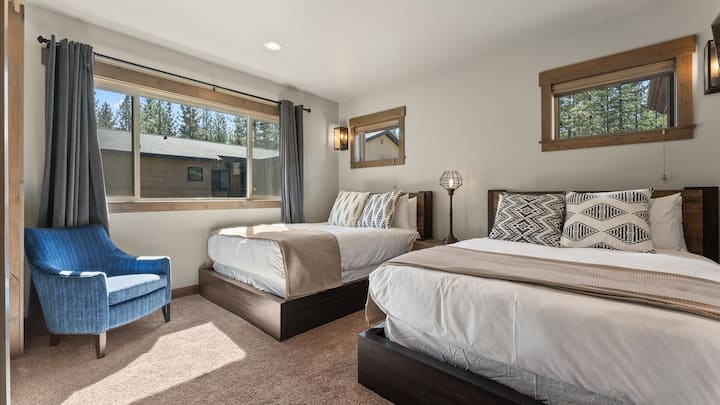 Kamar 209: Lantai utama, dua tempat tidur queen, kamar mandi dalam, jendela besar dengan pemandangan hutan, kursi aksen, pencahayaan modern.