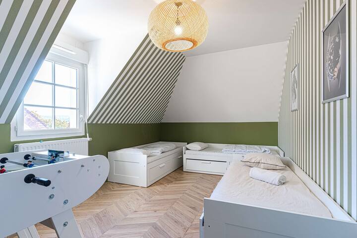 Habitación infantil con 3 camas individuales y futbolín