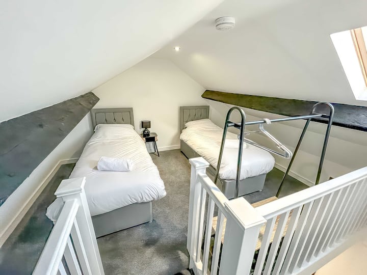 Vitanda viwili vya mtu mmoja katika eneo la dari lililobadilishwa