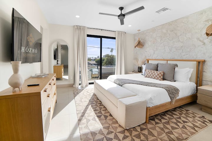 Relax in the spacious primary suite featuring a king bed, stylish furnishings, and a private ensuite bathroom.