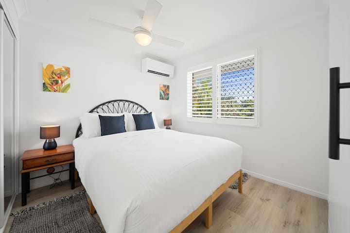 ห้องนอนที่สองมีเตียงควีนไซส์ ตู้เก็บของแบบกระจก เครื่องปรับอากาศ และวิวทิวทัศน์ที่ให้ความรู้สึกสงบในแต่ละเช้า