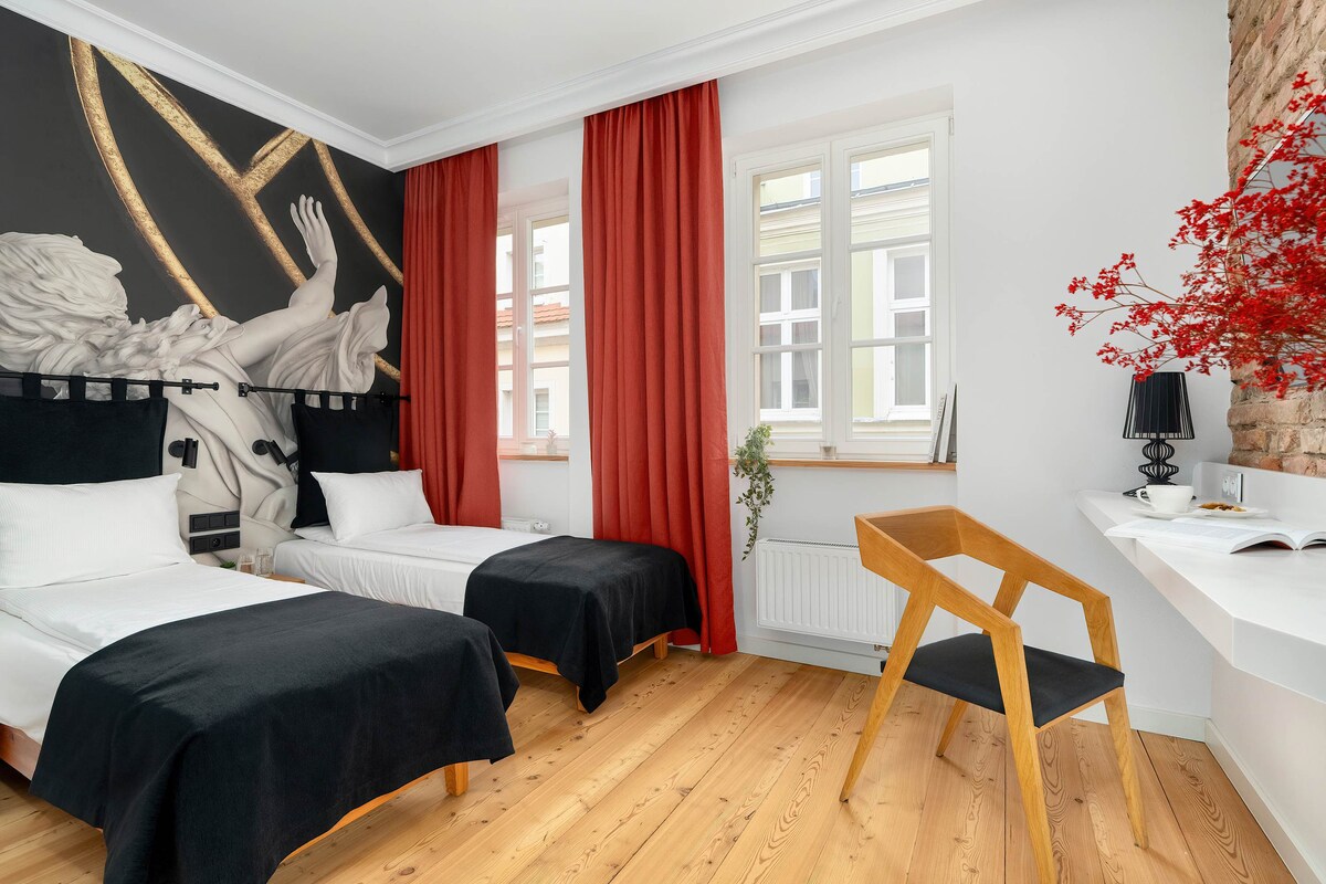 ნათელი, თანამედროვედ გაფორმებული საძინებელი ორი ცალ-ცალკე საწოლით.