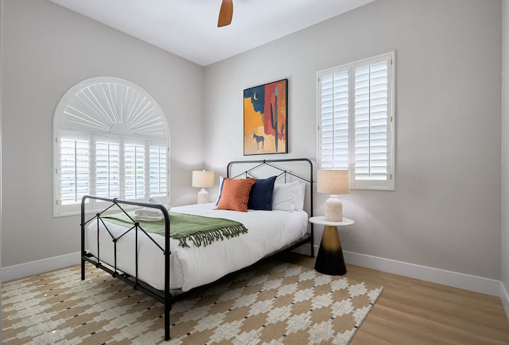 Удобна четврта спална соба со кревет од типот „queen“, топло осветлување и уметнички дела инспирирани од пустината, создавајќи мирно и привлечно засолниште.