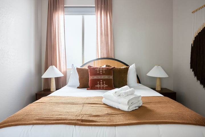 Втора спална соба со кревет „queen“, топли кафеави тонови, со плакар и единечен тоалет со пристап до бањата „Jack-and-Jill“.