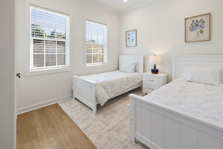 غرفة مريحة تضم سريرين صغيرين مع خزانة ملابس — مثالية للضيوف الإضافيين أو الصغار.