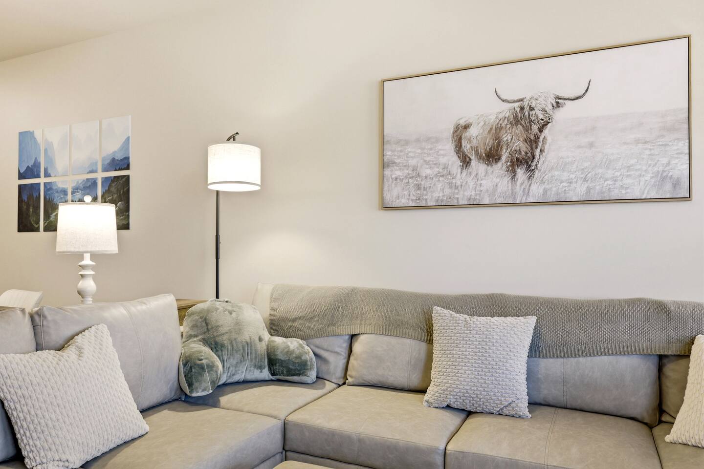 Cozy sectional, soft lighting, and serene art for relaxed nights