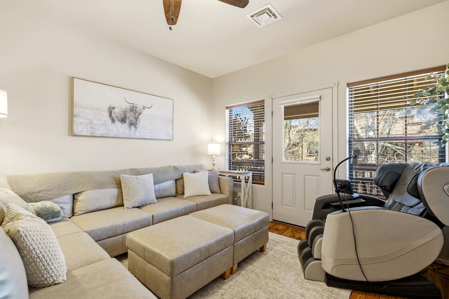 Bright lounge with roomy sectional, ottomans, and dual massage chairs