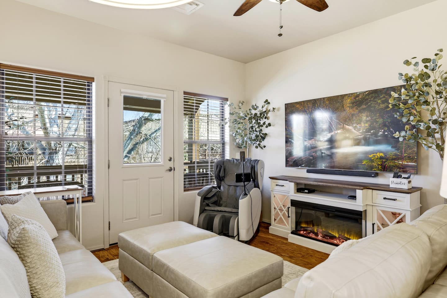 Living room with massage chair, 75" 4K TV, and electric fireplace