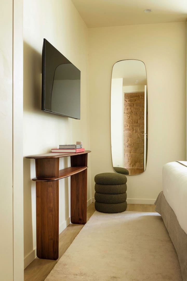 Një dhomë luksoze me një krevat dopio për net të qeta dhe një televizor 
