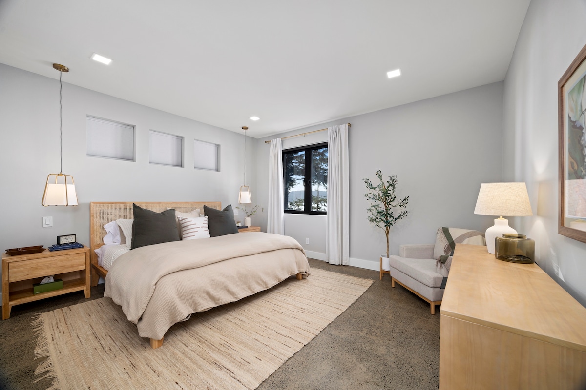 Retiro del dormitorio principal con tonos suaves, texturas naturales y vistas relajantes: relájate con comodidad sin esfuerzo.