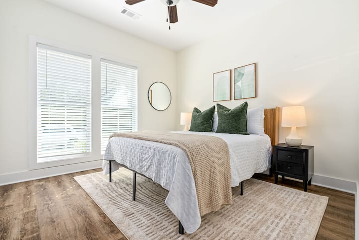 მარტივი და მშვიდი მეორე საძინებელი 152‑179 სმ ზომის საწოლით, რბილი თეთრეულითა და ბუნებრივი სინათლით.