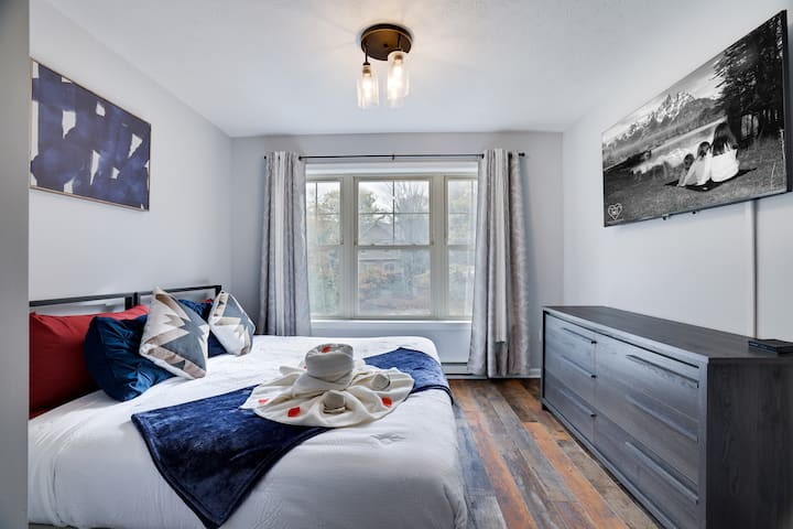 חדר שינה מזמין עם מיטת קינג סייז - ליהנות מלילות שלווים על מיטת קינג סייז קטיפה, להירגע עם התוכניות המועדפות עליכם בטלוויזיה החכמה, ולנצל את הגישה הקלה לחדר רחצה מלא בקרבת מקום. שילוב מושלם של נוחות ונוחות.