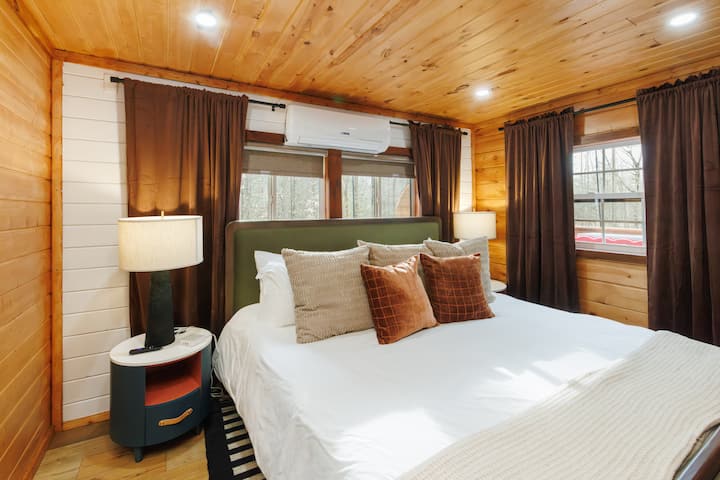 Another view of your cozy retreat—plush bedding, warm layers, and blackout shades that create the perfect space to curl up and fully relax.