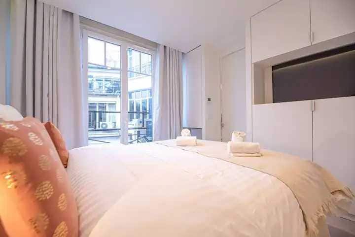 Una habitación con una cama queen size y una TV 