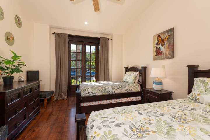 Dormitorio de la planta baja con cama tamaño queen y cama individual