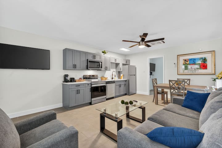 Priestranná hlavná obývacia zóna s modernou kuchyňou, jedálenským stolom a útulným posedením