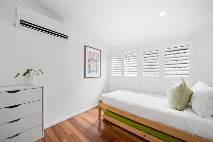 La luminosa habitación individual con cama nido ofrece una configuración flexible para dormir y un amplio espacio de almacenamiento.