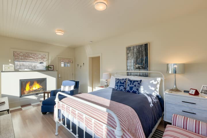 The primary bedroom features a queen bed, a fireplace, and comfortable seating.